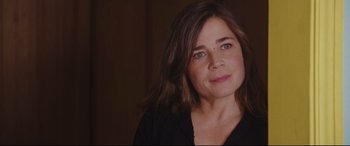 Movie still from “Everybody Loves Jeanne” (2022), directed by Céline Devaux – A person wearing a black shirt; Close Up shot, Over the shoulder angle