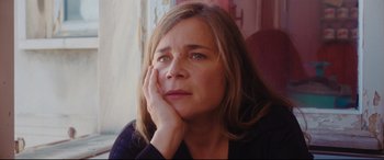 Movie still from “Everybody Loves Jeanne” (2022), directed by Céline Devaux – A person with her hand on her face; Close Up shot, Low angle