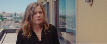 Movie still from “Everybody Loves Jeanne” (2022), directed by Céline Devaux – A person standing in front of a window; Close Up shot, Over the shoulder angle