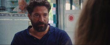 Movie still from “Everybody Loves Jeanne” (2022), directed by Céline Devaux – A man with a beard is standing in front of a woman; Close Up shot, Over the shoulder angle