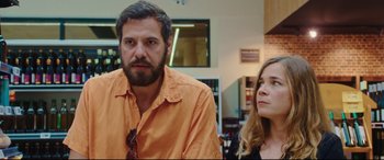 Movie still from “Everybody Loves Jeanne” (2022), directed by Céline Devaux – A man and a woman standing next to each other in a room; Medium shot, Over the shoulder angle