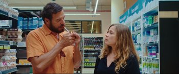 Movie still from “Everybody Loves Jeanne” (2022), directed by Céline Devaux – A man and a woman in a grocery store; Medium shot, Over the shoulder angle