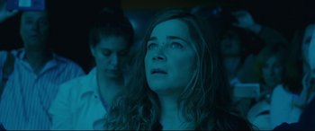 Movie still from “Everybody Loves Jeanne” (2022), directed by Céline Devaux – A woman with long brown hair looking up at the sky; Close Up shot, Low angle