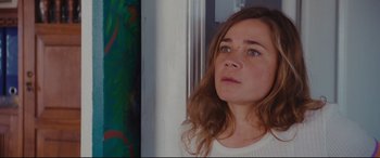 Movie still from “Everybody Loves Jeanne” (2022), directed by Céline Devaux – A person with long brown hair; Close Up shot, Over the shoulder angle