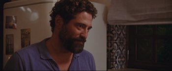 Movie still from “Everybody Loves Jeanne” (2022), directed by Céline Devaux – A man with curly hair and a beard looking to his left; Close Up shot, Over the shoulder angle
