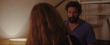 Movie still from “Everybody Loves Jeanne” (2022), directed by Céline Devaux – A man with a beard looking at a woman in a mirror; Medium shot, Over the shoulder angle