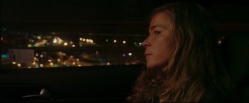 Movie still from “Everybody Loves Jeanne” (2022), directed by Céline Devaux – A woman sitting in a car at night looking out of the window; Close Up shot, Over the shoulder angle