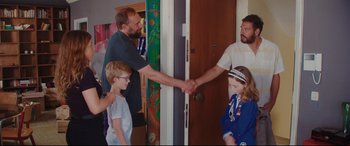 Movie still from “Everybody Loves Jeanne” (2022), directed by Céline Devaux – A man and a woman shaking hands with two other people; Medium shot, Over the shoulder angle