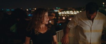 Movie still from “Everybody Loves Jeanne” (2022), directed by Céline Devaux – A woman standing next to a man on a balcony at night; Medium shot, Over the shoulder angle
