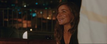 Movie still from “Everybody Loves Jeanne” (2022), directed by Céline Devaux – A woman with long brown hair smiling at the camera; Close Up shot, Over the shoulder angle