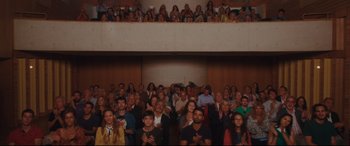 Movie still from “Everybody Loves Jeanne” (2022), directed by Céline Devaux – A group of people standing in front of an audience; Extreme Wide shot, Low angle