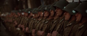 Movie still from “Evita” (1996), directed by Alan Parker – A group of men in military fatigues standing in a line; Close Up shot, Low angle