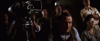 Movie still from “Evita” (1996), directed by Alan Parker – A group of men standing next to each other in a dark room; Close Up shot, Low angle
