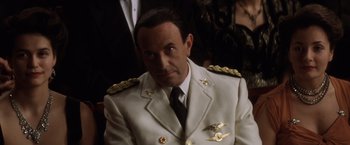 Movie still from “Evita” (1996), directed by Alan Parker – A person wearing a suit and tie; Close Up shot, High angle