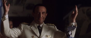 Movie still from “Evita” (1996), directed by Alan Parker – A person wearing a suit and tie; Close Up shot, Low angle