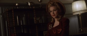 Movie still from “Evita” (1996), directed by Alan Parker – A woman in a red dress and a brown hat; Close Up shot, Over the shoulder angle