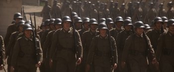 Movie still from “Evita” (1996), directed by Alan Parker – A large group of soldiers marching down a street; Wide shot, High angle