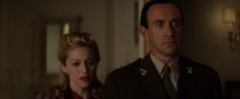 Movie still from “Evita” (1996), directed by Alan Parker – A man and a woman standing next to each other; Close Up shot, Low angle