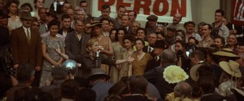 Movie still from “Evita” (1996), directed by Alan Parker – A group of people standing in front of a crowd; Medium shot, High angle
