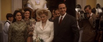 Movie still from “Evita” (1996), directed by Alan Parker – A man and a woman standing next to each other; Medium shot, Low angle