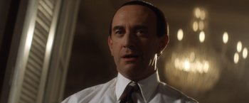 Movie still from “Evita” (1996), directed by Alan Parker – A person wearing a shirt and a tie; Close Up shot, Low angle