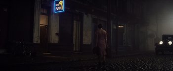 Movie still from “Evita” (1996), directed by Alan Parker – A woman walking down the street at night with a suitcase; Wide shot, Low angle