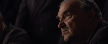 Movie still from “Evita” (1996), directed by Alan Parker – An older man with a mustache looking to his left; Close Up shot, Low angle