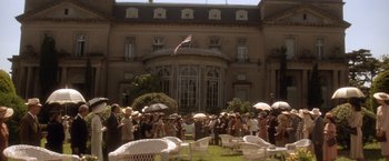 Movie still from “Evita” (1996), directed by Alan Parker – A group of people standing in front of a large building; Extreme Wide shot, High angle