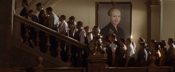 Movie still from “Evita” (1996), directed by Alan Parker – A group of people standing on a staircase near a painting; Wide shot, Low angle