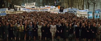 Movie still from “Evita” (1996), directed by Alan Parker – A large group of women are marching down the street; Wide shot, High angle