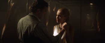 Movie still from “Evita” (1996), directed by Alan Parker – A man and a woman are holding hands in the dark; Medium shot, Low angle