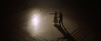 Movie still from “Evita” (1996), directed by Alan Parker – A couple of people that are dancing in a room; Extreme Wide shot, High angle