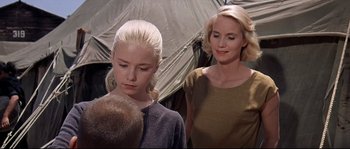Movie still from “Exodus” (1960), directed by Otto Preminger – A woman standing next to a young girl in front of a tent; Close Up shot, Over the shoulder angle