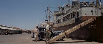 Movie still from “Exodus” (1960), directed by Otto Preminger – A group of men standing next to each other near a boat; Wide shot, Low angle