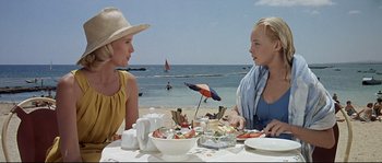Movie still from “Exodus” (1960), directed by Otto Preminger – Two young women sitting at a table on the beach; Medium shot, High angle
