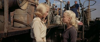 Movie still from “Exodus” (1960), directed by Otto Preminger – Two women standing next to each other in front of a crowd; Medium shot, Over the shoulder angle