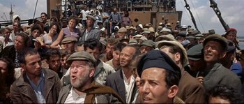 Movie still from “Exodus” (1960), directed by Otto Preminger – A large group of people wearing hats and standing in a crowd; Wide shot, High angle
