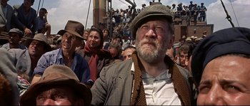 Movie still from “Exodus” (1960), directed by Otto Preminger – An old man with a beard and a hat in a crowd of people; Medium shot, Low angle