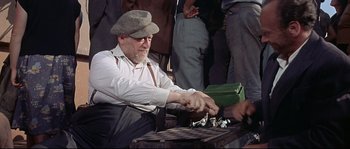 Movie still from “Exodus” (1960), directed by Otto Preminger – An old man playing a game of chess with a group of people; Medium shot, High angle