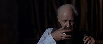 Movie still from “Exodus” (1960), directed by Otto Preminger – An older man with a mustache is drinking a cup of coffee; Close Up shot, High angle