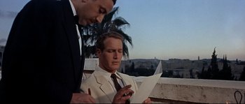 Movie still from “Exodus” (1960), directed by Otto Preminger – Two men in suits looking at a piece of paper; Medium shot, Low angle