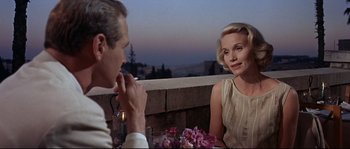 Movie still from “Exodus” (1960), directed by Otto Preminger – A man and a woman are sitting at a table; Medium shot, Over the shoulder angle