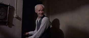 Movie still from “Exodus” (1960), directed by Otto Preminger – An older man in a white shirt and a vest; Medium shot, Low angle