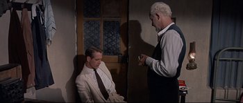 Movie still from “Exodus” (1960), directed by Otto Preminger – A man in a white suit and a man in a black tie; Medium shot, Over the shoulder angle