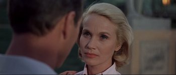 Movie still from “Exodus” (1960), directed by Otto Preminger – An older blonde woman with blue eyes looks at a younger man; Close Up shot, Over the shoulder angle