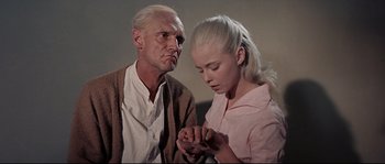 Movie still from “Exodus” (1960), directed by Otto Preminger – An older man and a young woman looking at a cell phone; Medium shot, Low angle