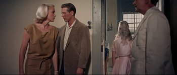 Movie still from “Exodus” (1960), directed by Otto Preminger – A man and a woman standing next to each other in front of a door; Medium shot, Over the shoulder angle