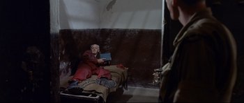 Movie still from “Exodus” (1960), directed by Otto Preminger – An older man sitting on a bed in a room; Wide shot, High angle