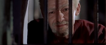 Movie still from “Exodus” (1960), directed by Otto Preminger – An older man with a beard and mustache behind bars looking at the camera; Close Up shot, Low angle