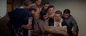 Movie still from “Exodus” (1960), directed by Otto Preminger – A group of men standing around a paper bag; Medium shot, High angle